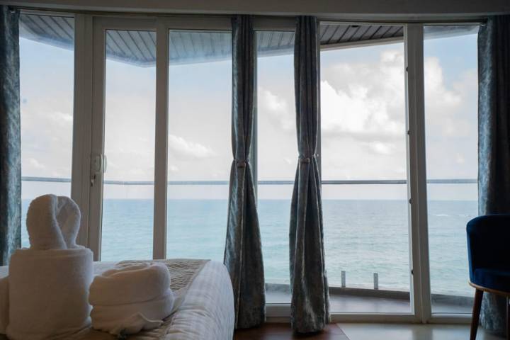 Curved glass windows in a room looking straight out to the sea