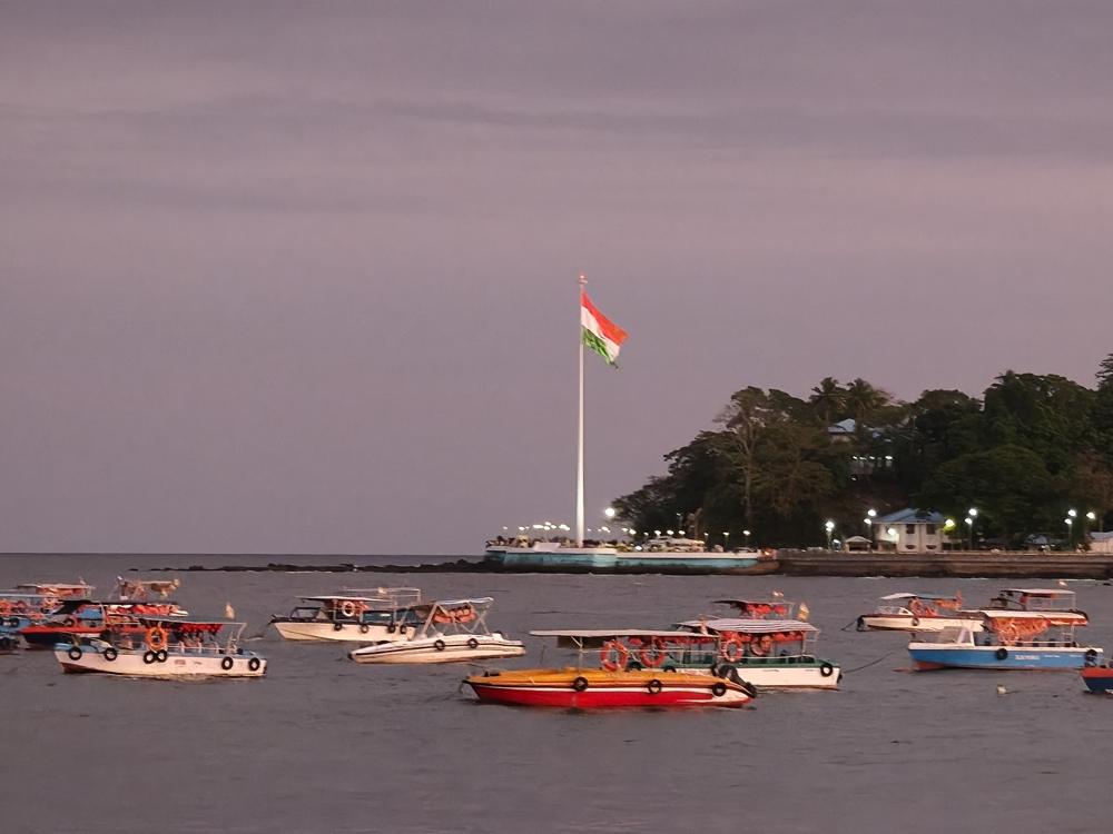 Tiranga Memorial flag at dusk over boats